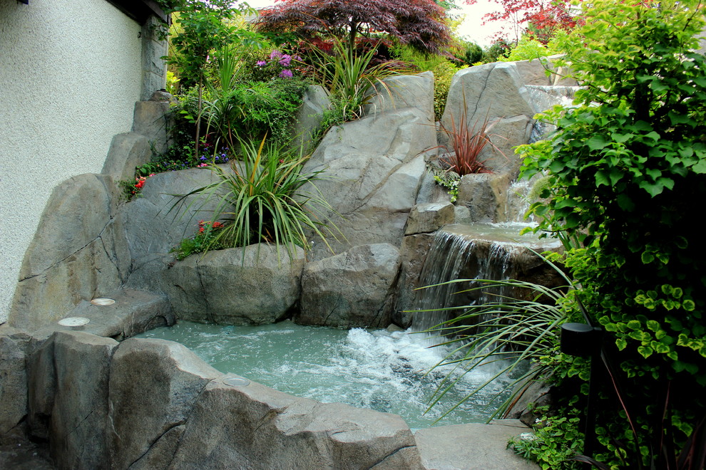 Design ideas for a small traditional backyard partial sun garden in Vancouver with a water feature.