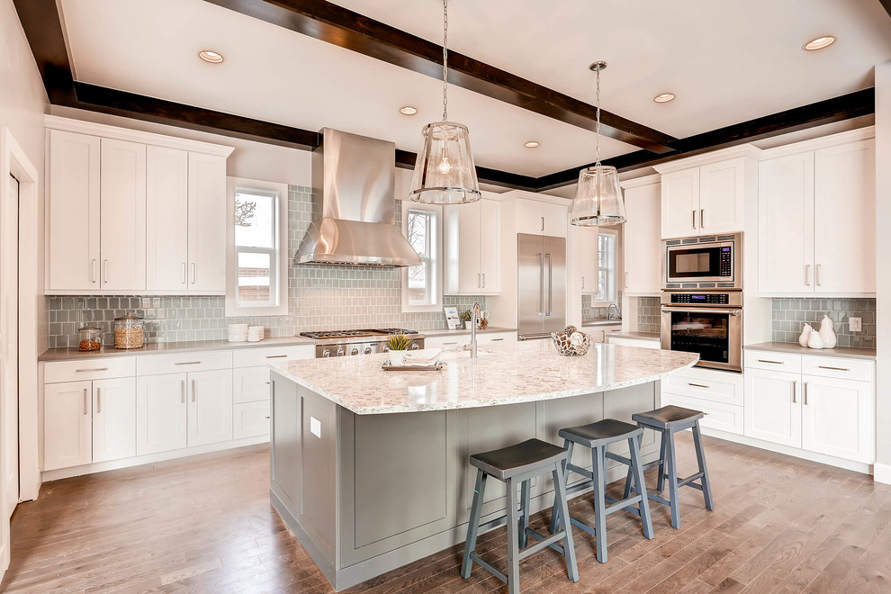 Example of a large transitional l-shaped medium tone wood floor open concept kitchen design in Denver with an undermount sink, shaker cabinets, white cabinets, granite countertops, gray backsplash, glass tile backsplash, stainless steel appliances and an island