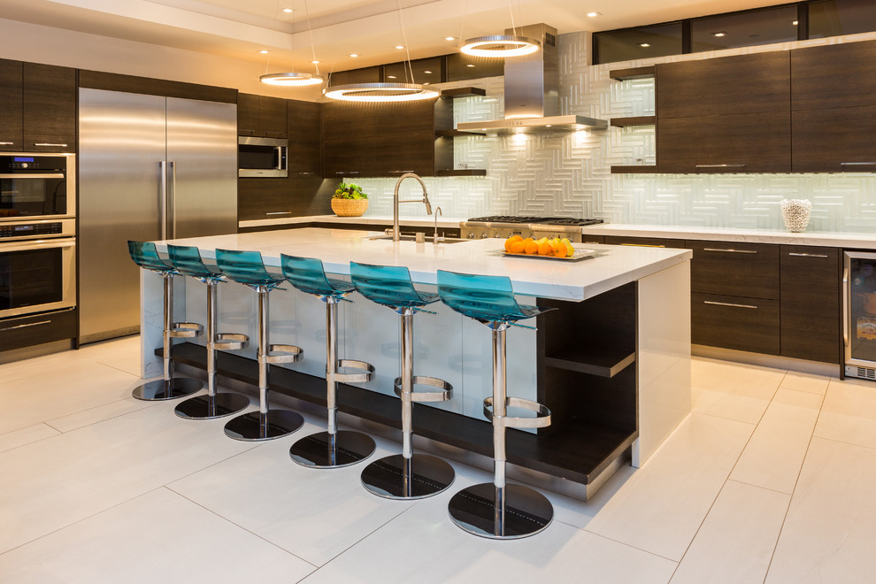 Mid-sized contemporary l-shaped open plan kitchen in Orange County with a farmhouse sink, flat-panel cabinets, dark wood cabinets, blue splashback, glass tile splashback, stainless steel appliances, with island, white floor, white benchtop, quartz benchtops and porcelain floors.