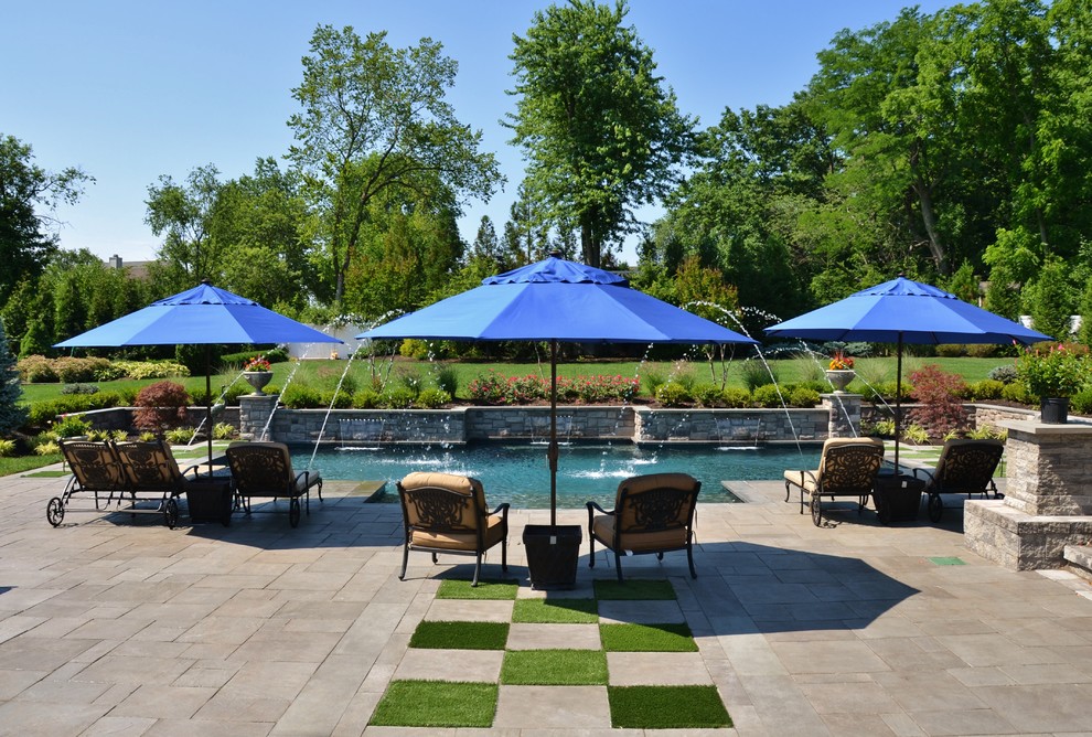 Photo of a large contemporary backyard custom-shaped pool in New York with a water feature.