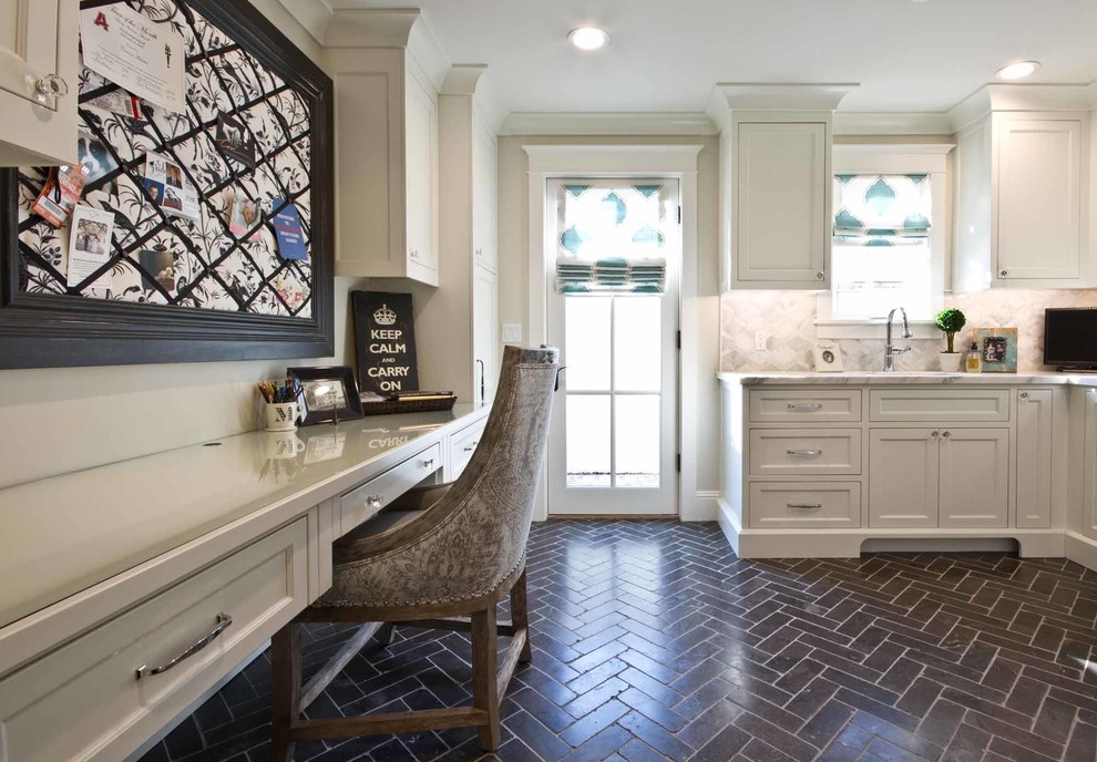 Photo of a large country l-shaped utility room in Phoenix with an undermount sink, recessed-panel cabinets, white cabinets, marble benchtops, grey walls, slate floors and black floor.