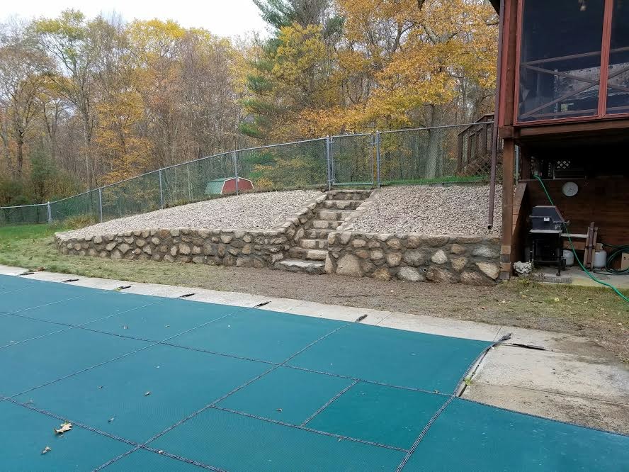 Example of a large mountain style backyard concrete paver and rectangular lap pool design in Providence