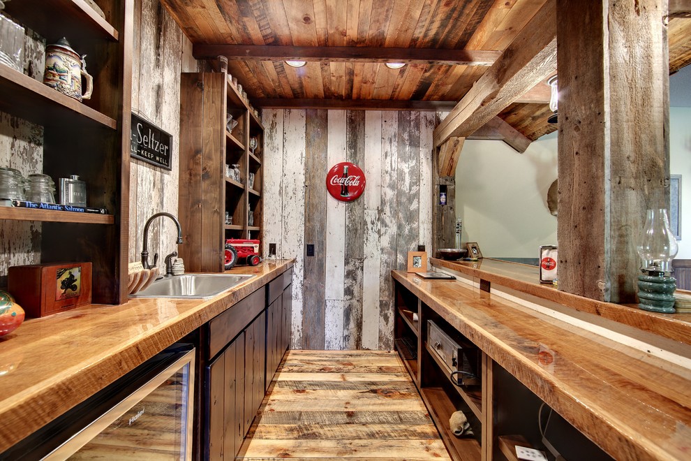 Country galley wet bar in Minneapolis with a drop-in sink, dark wood cabinets, wood benchtops, timber splashback, medium hardwood floors and brown floor.