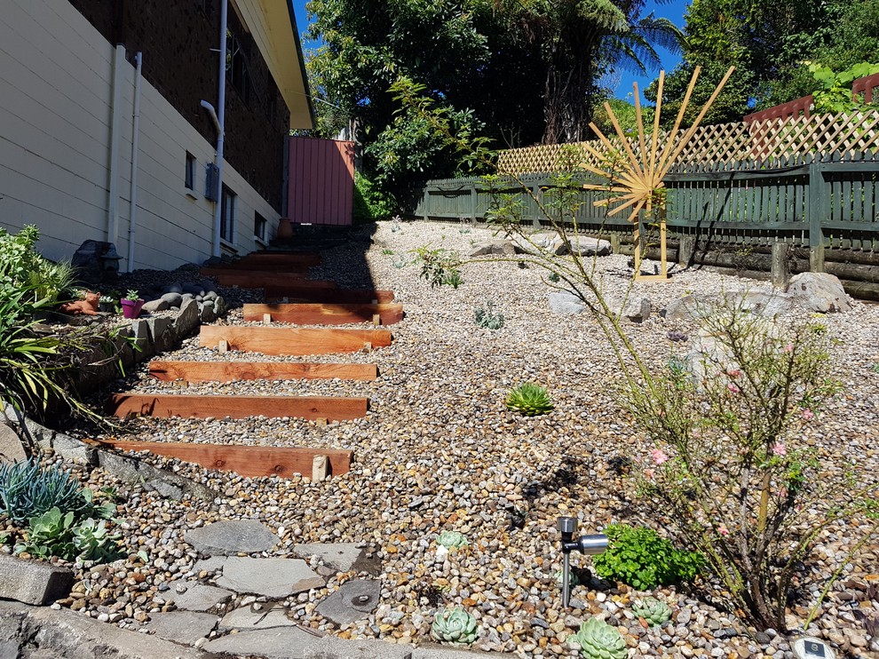 Photo of a mid-sized asian sloped partial sun xeriscape in Other with gravel.