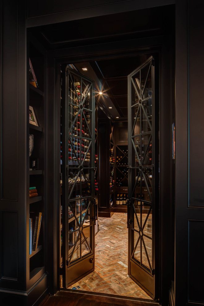 This is an example of a transitional wine cellar in Houston with brick floors and display racks.