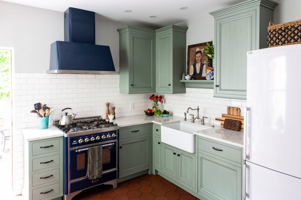 Foto di una cucina a L tradizionale di medie dimensioni con lavello stile country, ante verdi, paraspruzzi bianco, penisola e top bianco