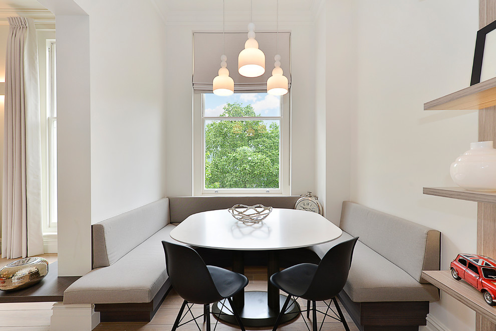 Photo of a scandinavian dining room in London with white walls, light hardwood floors and no fireplace.