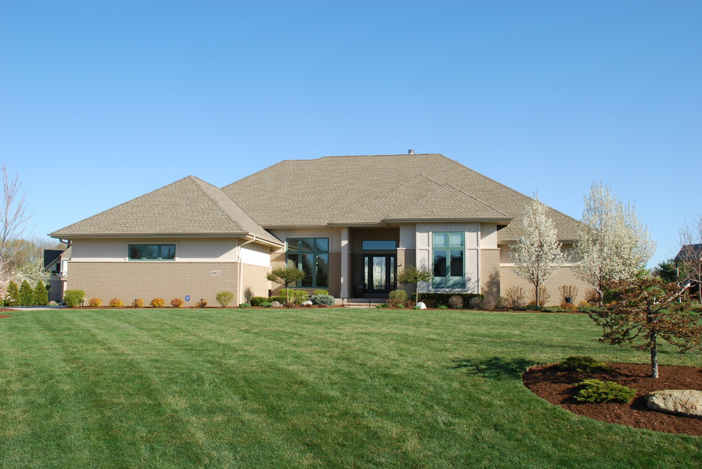 Large transitional beige one-story mixed siding house exterior photo in Milwaukee with a hip roof and a shingle roof