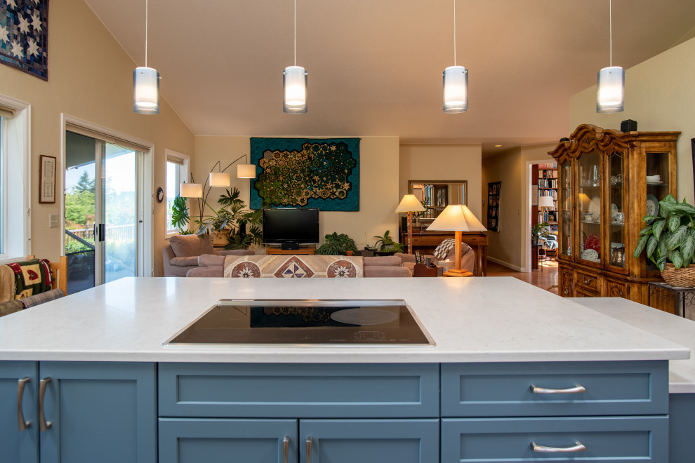 Design ideas for a mid-sized transitional l-shaped open plan kitchen in Seattle with an undermount sink, recessed-panel cabinets, blue cabinets, quartz benchtops, blue splashback, ceramic splashback, stainless steel appliances, vinyl floors, with island, blue floor, grey benchtop and vaulted.