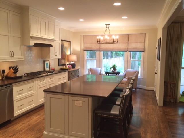 Inspiration for a mid-sized transitional galley medium tone wood floor eat-in kitchen remodel in Birmingham with an undermount sink, shaker cabinets, white cabinets, quartzite countertops, white backsplash, subway tile backsplash, stainless steel appliances and an island