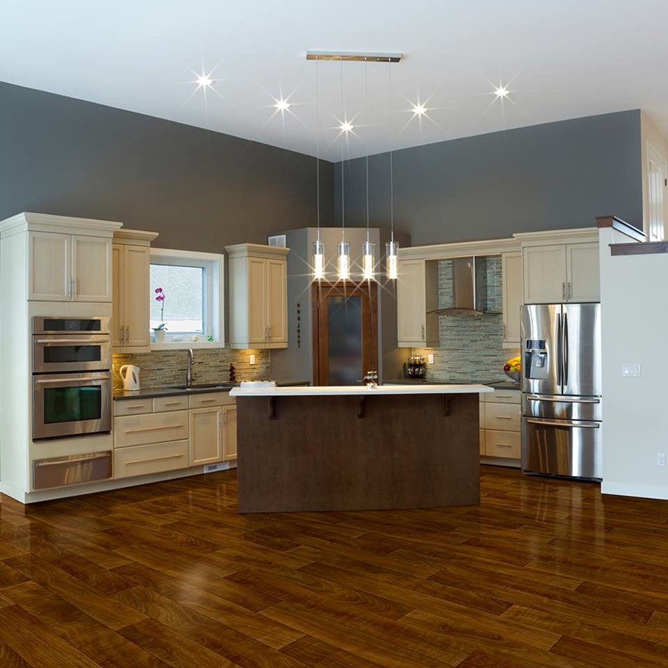 Example of a mid-sized transitional l-shaped medium tone wood floor and brown floor kitchen design with shaker cabinets, beige cabinets, quartz countertops, gray backsplash, matchstick tile backsplash, stainless steel appliances and an island
