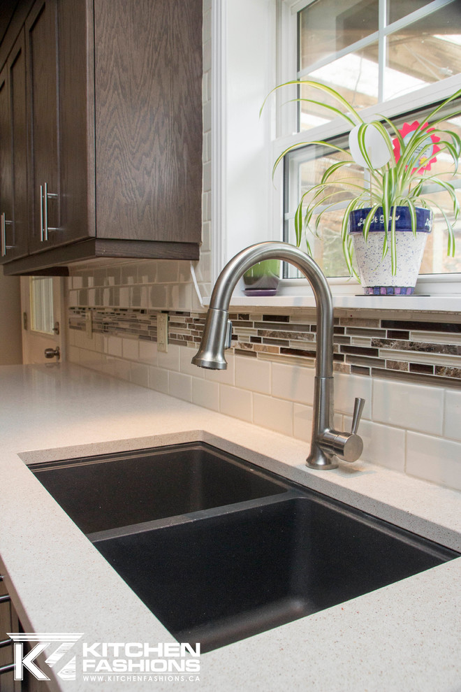 Inspiration for a mid-sized transitional l-shaped enclosed kitchen remodel in Toronto with an undermount sink, shaker cabinets, dark wood cabinets, quartz countertops, multicolored backsplash, subway tile backsplash, stainless steel appliances and an island