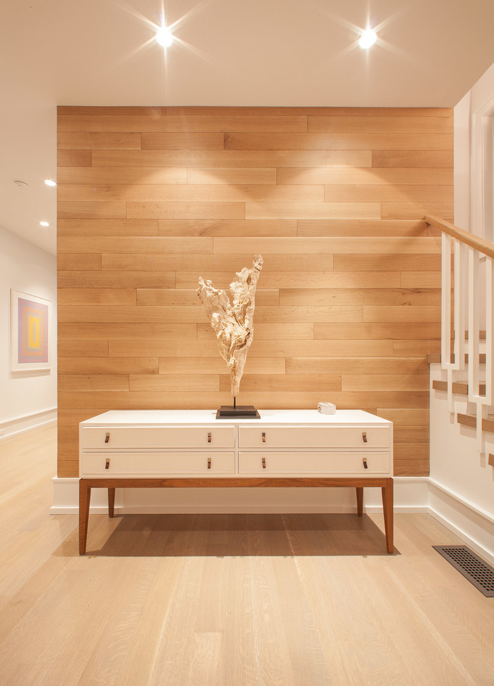 Photo of a contemporary entryway in Austin with white walls, light hardwood floors and a light wood front door.