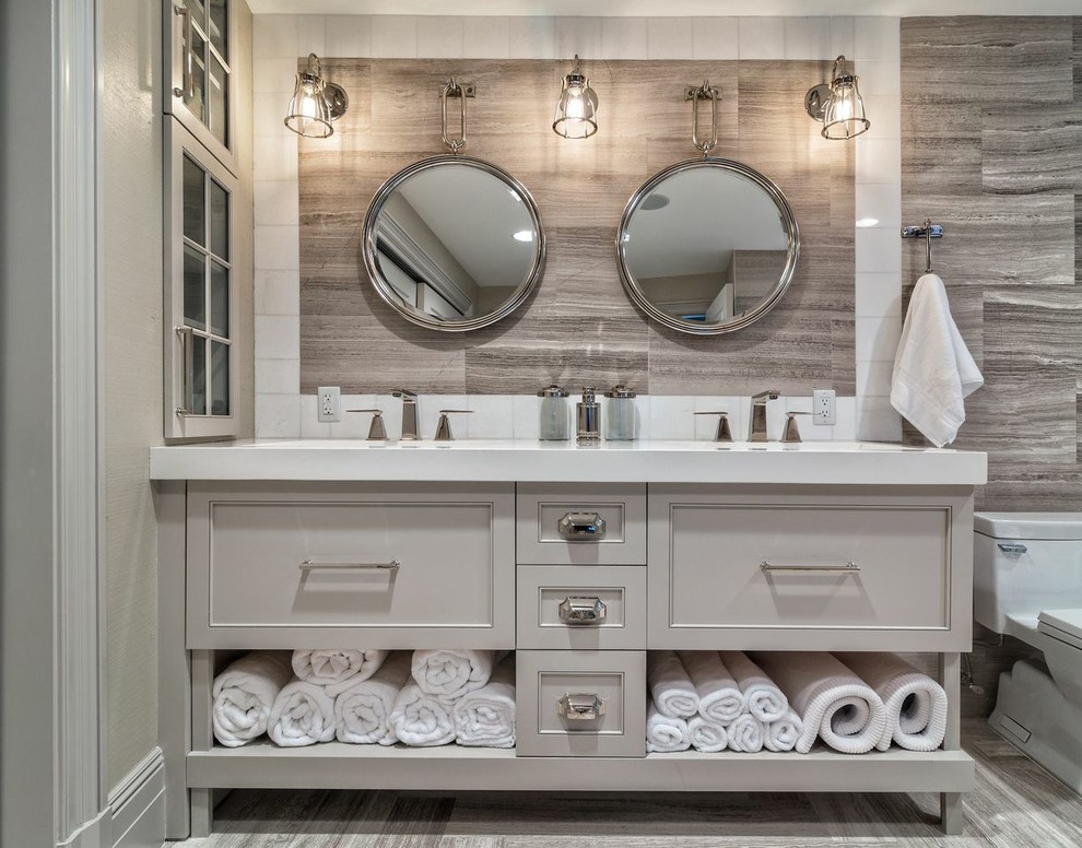 Design ideas for a mid-sized transitional master bathroom in Boston with recessed-panel cabinets, grey cabinets, brown tile, porcelain tile, brown walls, porcelain floors, an undermount sink, solid surface benchtops and brown floor.