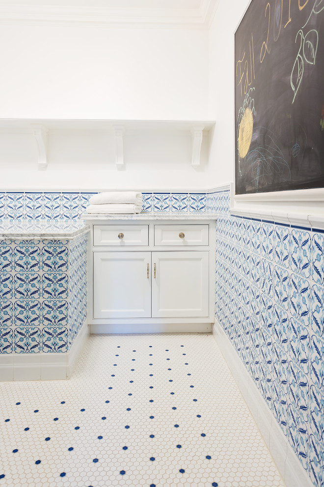 This is an example of a large contemporary l-shaped dedicated laundry room in Los Angeles with beaded inset cabinets, white cabinets, marble benchtops, white walls, ceramic floors, white floor and grey benchtop.