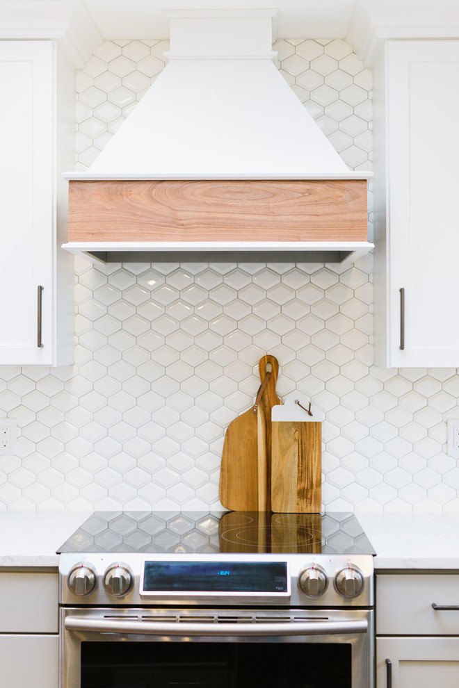 Open concept kitchen - mid-sized transitional u-shaped medium tone wood floor and brown floor open concept kitchen idea with an undermount sink, shaker cabinets, white cabinets, quartz countertops, white backsplash, porcelain backsplash, stainless steel appliances, an island and white countertops