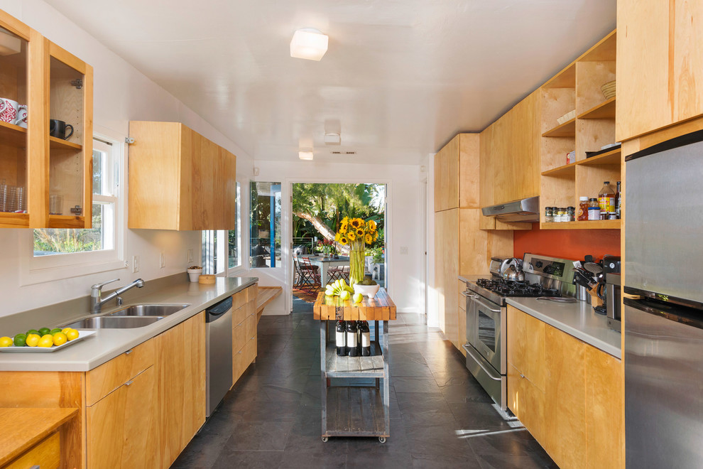 Inspiration for a mid-sized midcentury galley eat-in kitchen in Phoenix with flat-panel cabinets, light wood cabinets, quartz benchtops, stainless steel appliances, slate floors, a double-bowl sink, orange splashback and with island.