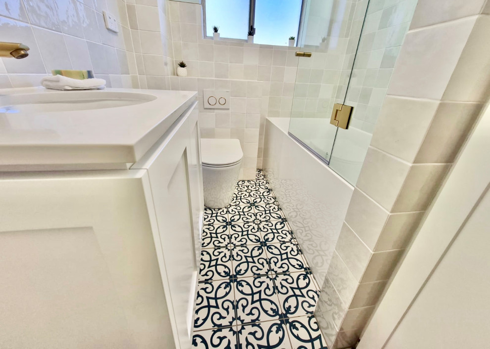 Inredning av ett litet vit vitt en-suite badrum, med skåp i shakerstil, vita skåp, ett fristående badkar, en dusch/badkar-kombination, vit kakel, keramikplattor, gröna väggar, klinkergolv i porslin, ett undermonterad handfat, bänkskiva i kvarts, flerfärgat golv och dusch med gångjärnsdörr