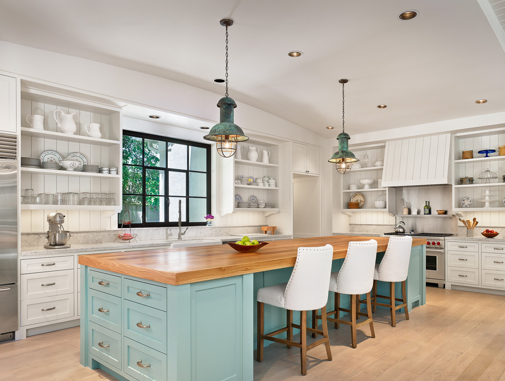 Inspiration for a large beach style l-shaped kitchen in Houston with a farmhouse sink, open cabinets, white cabinets, wood benchtops, white splashback, stainless steel appliances, light hardwood floors, with island and timber splashback.