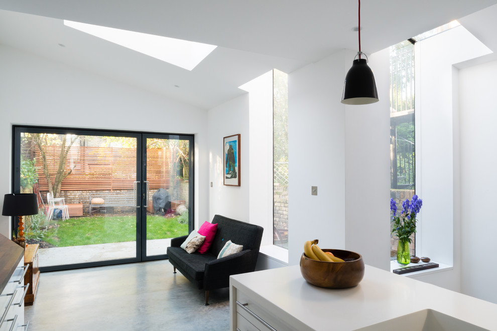 Inspiration for a medium sized contemporary galley kitchen/diner in London with a built-in sink, flat-panel cabinets, white cabinets, composite countertops, grey splashback, glass tiled splashback, integrated appliances, concrete flooring, an island, grey floors and white worktops.