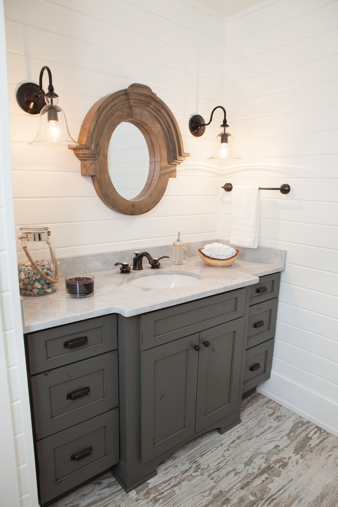 Inspiration for a small country powder room in Chicago with an undermount sink, shaker cabinets, distressed cabinets, marble benchtops, white walls, porcelain floors and grey benchtops.