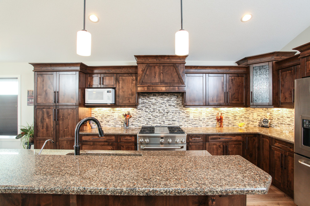 Example of a transitional l-shaped light wood floor eat-in kitchen design in Calgary with an undermount sink, shaker cabinets, dark wood cabinets, quartz countertops, gray backsplash, matchstick tile backsplash, stainless steel appliances and an island
