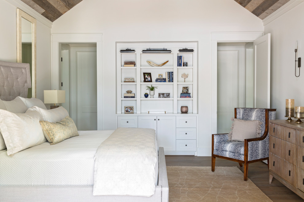 Cette image montre une chambre parentale traditionnelle avec un mur blanc, un sol en bois brun, aucune cheminée, un sol marron, un plafond voûté et un plafond en bois.
