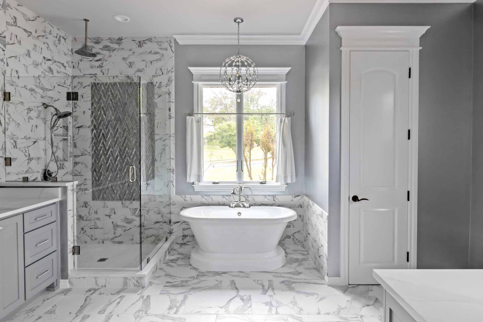 Exemple d'une salle de bain chic avec des portes de placard grises, une baignoire indépendante, une douche d'angle, un carrelage gris, du carrelage en marbre, un mur gris, un sol en marbre, un plan de toilette en marbre, une cabine de douche à porte battante, un plan de toilette blanc, des toilettes cachées, un placard à porte shaker, un sol gris et meuble-lavabo encastré.
