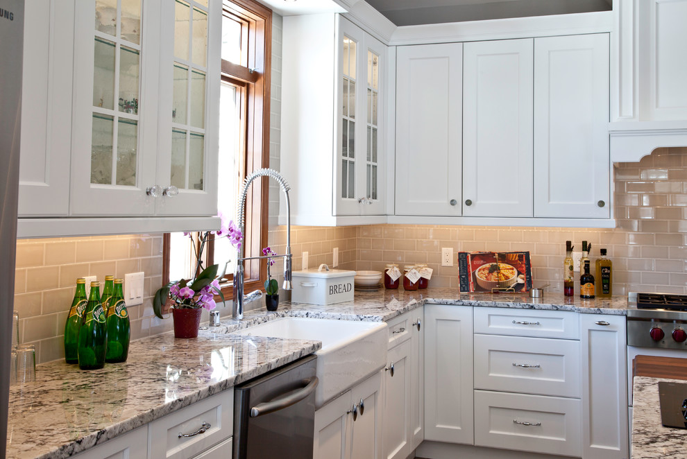 Example of a large transitional u-shaped slate floor and brown floor open concept kitchen design with a farmhouse sink, shaker cabinets, white cabinets, granite countertops, yellow backsplash, subway tile backsplash, stainless steel appliances and two islands