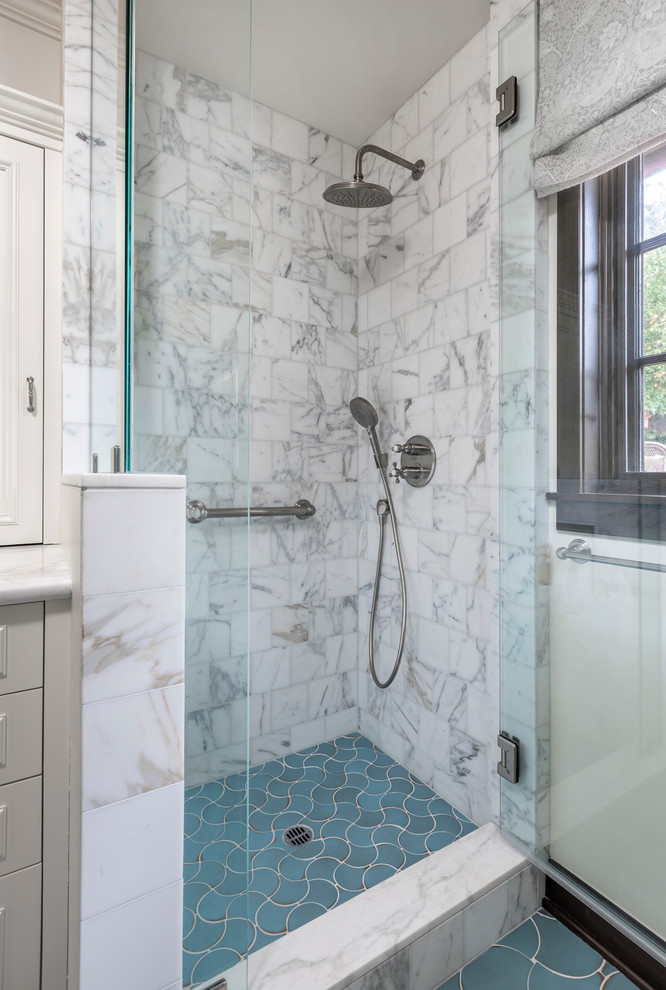 Photo of a small traditional bathroom in San Diego with raised-panel cabinets, blue cabinets, an alcove shower, a one-piece toilet, marble, white walls, ceramic floors, an undermount sink, marble benchtops, blue floor, a hinged shower door and white benchtops.
