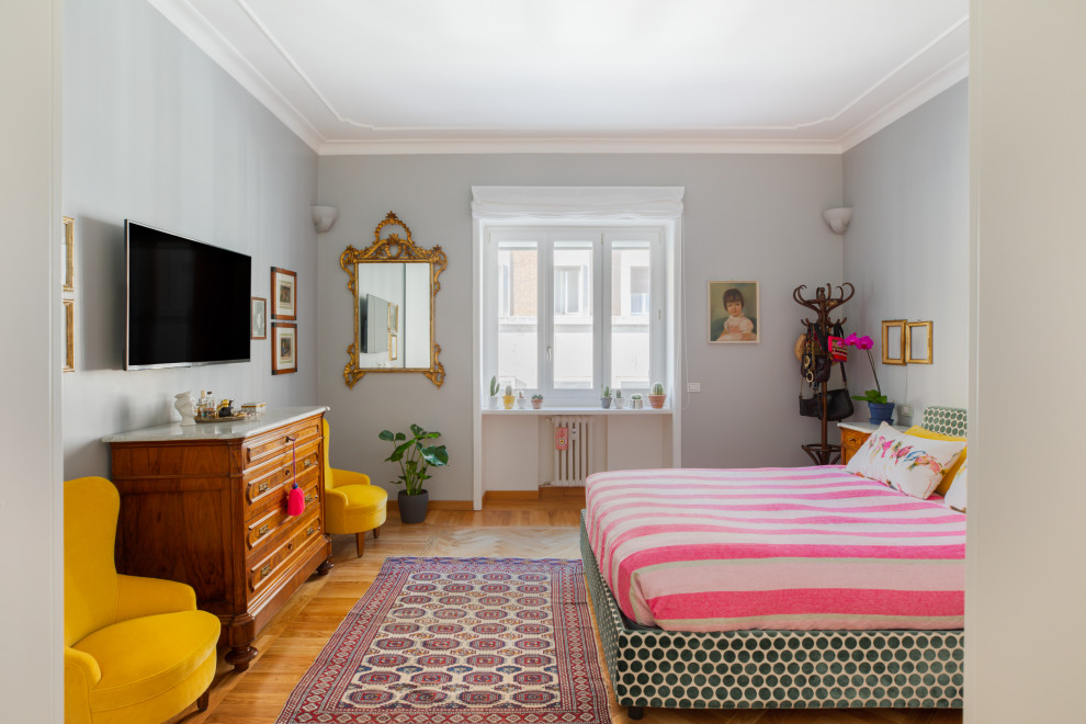 Ispirazione per una cameretta da letto boho chic con pareti grigie, pavimento in legno massello medio e pavimento marrone