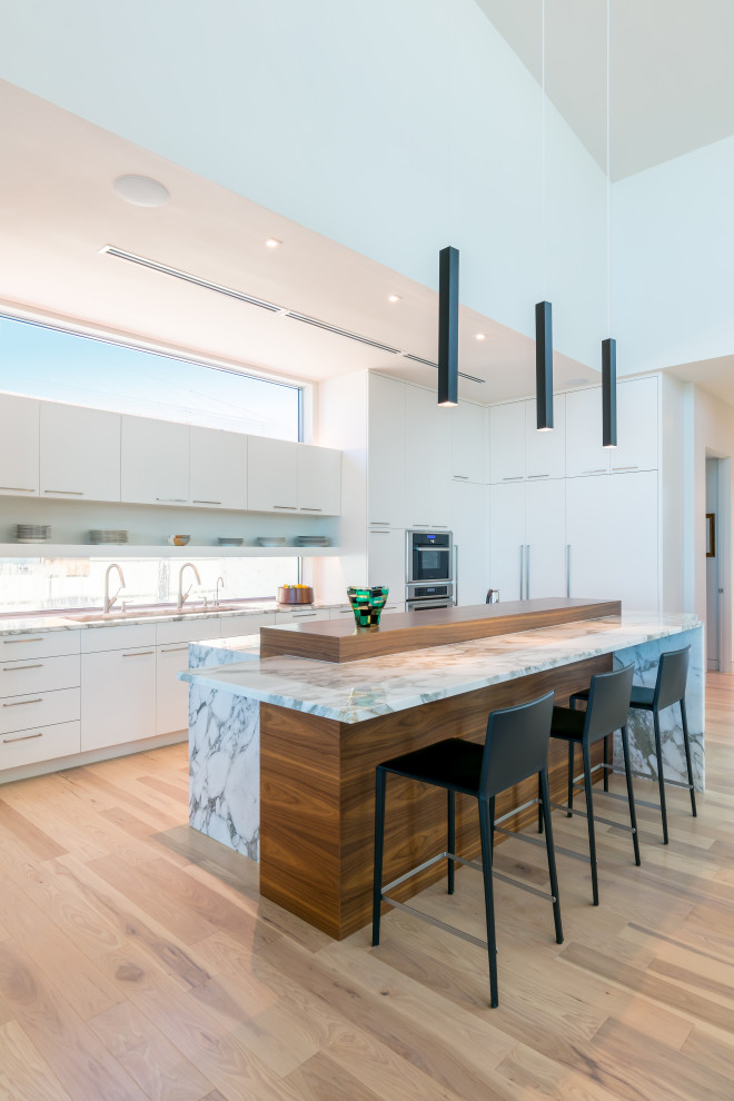 Foto på ett mellanstort funkis vit linjärt kök med öppen planlösning, med släta luckor, vita skåp, bänkskiva i kvarts, glaspanel som stänkskydd, integrerade vitvaror, mellanmörkt trägolv, en köksö och brunt golv