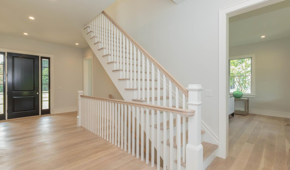 Inspiration for a large country wood straight staircase in New York with painted wood risers and wood railing.