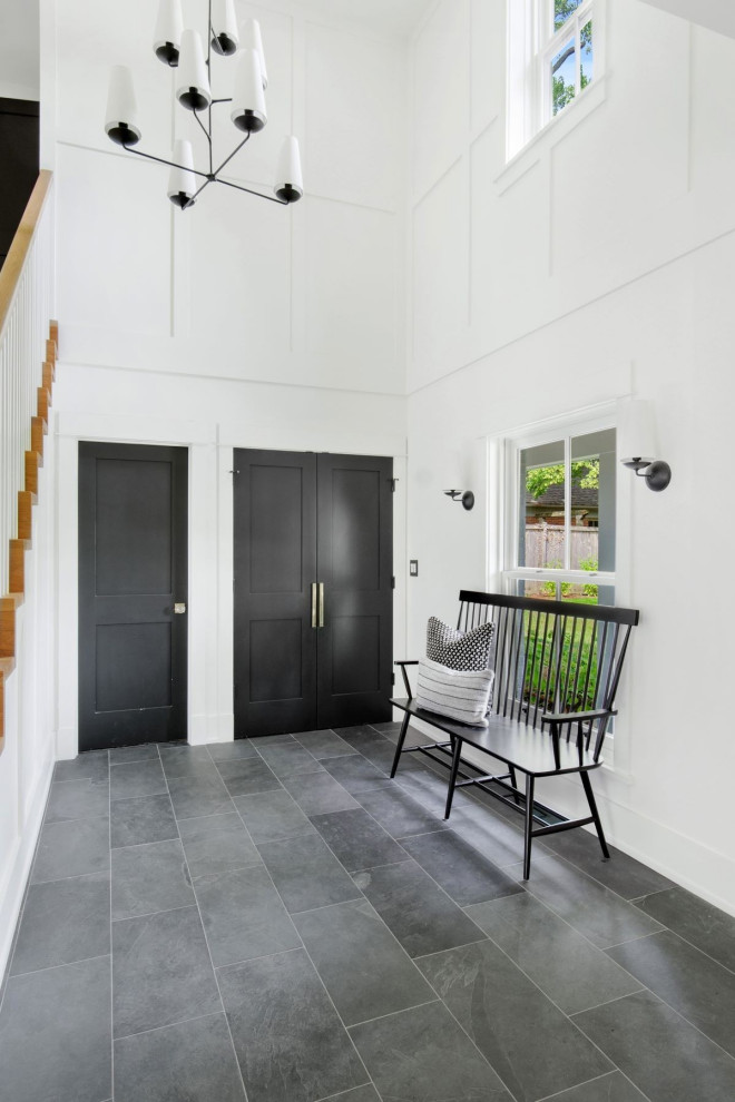Inspiration for a large transitional gray floor foyer remodel in Orlando with white walls and a black front door