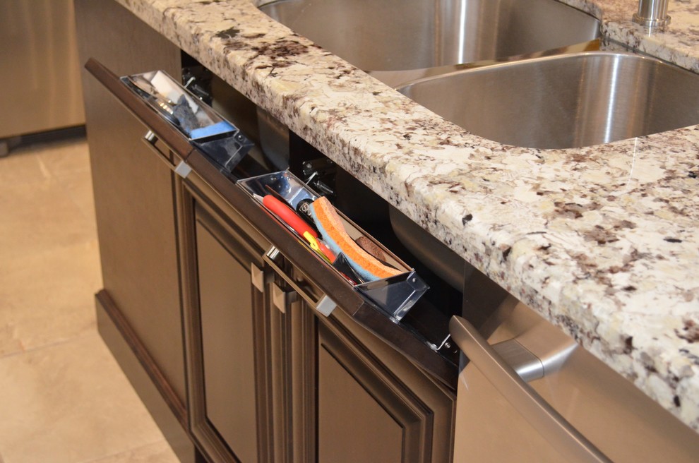 Mid-sized transitional l-shaped porcelain tile enclosed kitchen photo in Toronto with an undermount sink, raised-panel cabinets, dark wood cabinets, granite countertops, beige backsplash, stainless steel appliances and an island