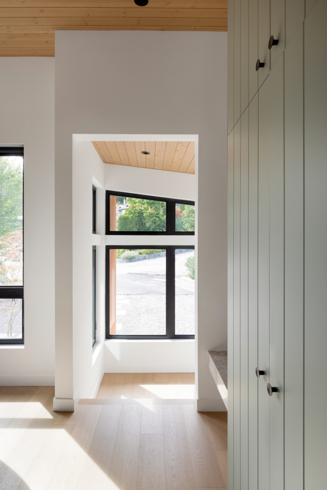 Inspiration pour un hall d'entrée design avec un mur blanc, parquet clair, une porte simple, une porte noire et un plafond en bois.