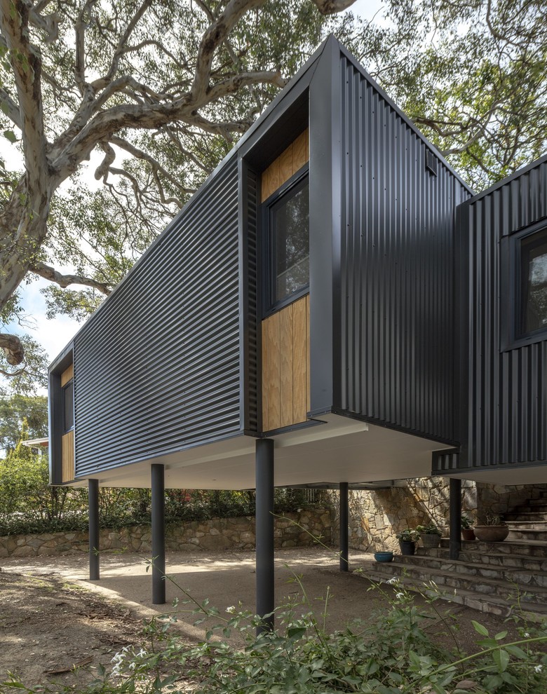 Small contemporary one-storey grey house exterior in Canberra - Queanbeyan with metal siding, a flat roof and a metal roof.