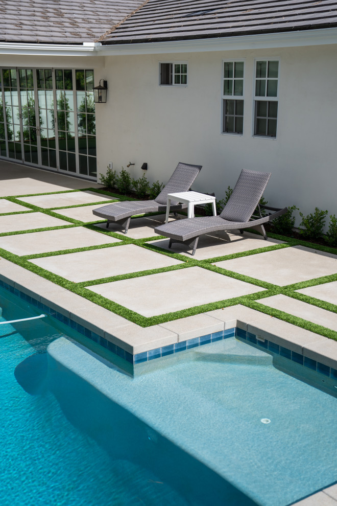 Example of a large transitional backyard concrete paver and rectangular lap hot tub design in Orange County