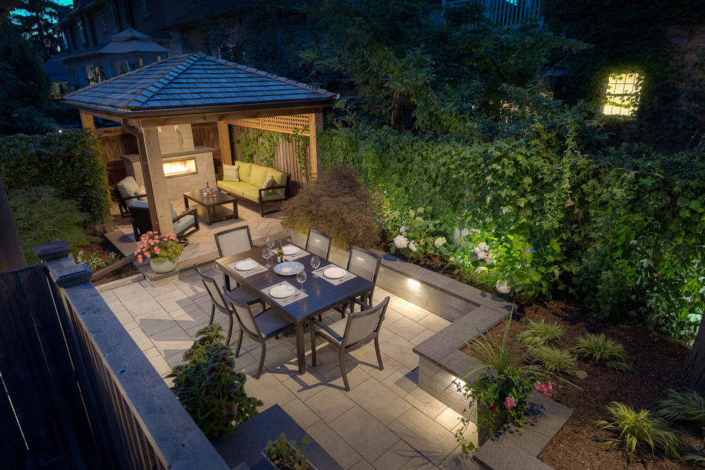 Foto di un giardino contemporaneo di medie dimensioni e dietro casa con un muro di contenimento e pavimentazioni in pietra naturale