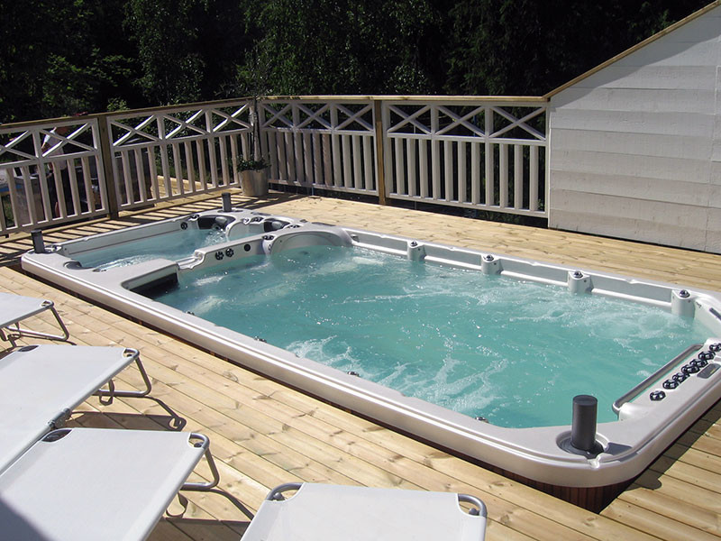 Photo of a mid-sized traditional backyard rectangular pool in Orange County with a hot tub and decking.