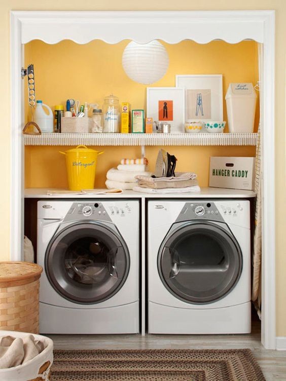 Esempio di un piccolo ripostiglio-lavanderia con pareti gialle e lavatrice e asciugatrice affiancate