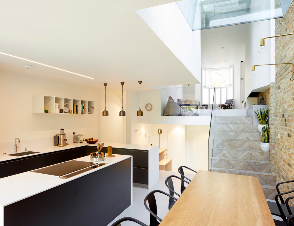 This is an example of a large contemporary l-shaped eat-in kitchen in London with flat-panel cabinets, dark wood cabinets, quartzite benchtops, concrete floors and with island.