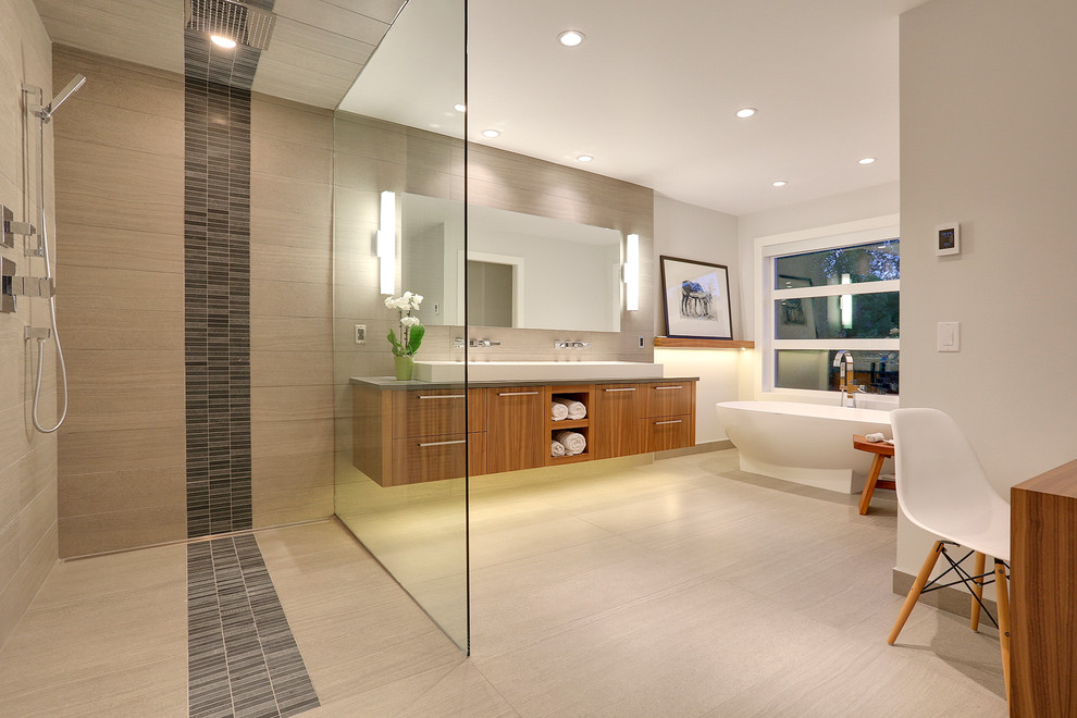 Contemporary master bathroom in Calgary with flat-panel cabinets, medium wood cabinets, a freestanding tub, a curbless shower, gray tile, grey walls, an integrated sink and an open shower.