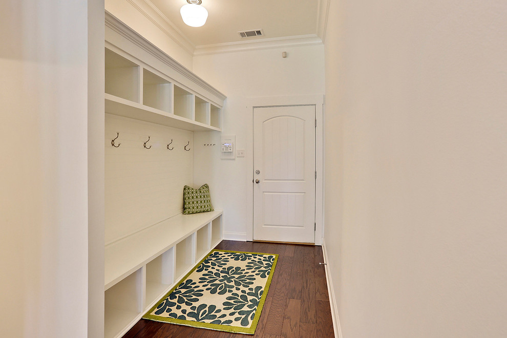 Design ideas for a beach style mudroom in New Orleans with white walls and dark hardwood floors.