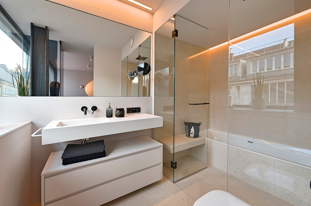 This is an example of a mid-sized contemporary master bathroom in Naples with flat-panel cabinets, white cabinets, an alcove tub, a shower/bathtub combo, white tile, stone slab, white walls, an integrated sink, solid surface benchtops and a hinged shower door.