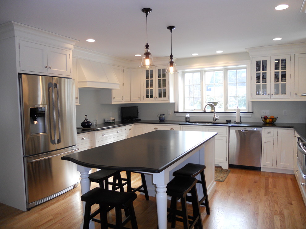Example of a large transitional u-shaped light wood floor eat-in kitchen design in Boston with a double-bowl sink, beaded inset cabinets, white cabinets, granite countertops, gray backsplash, stainless steel appliances and an island
