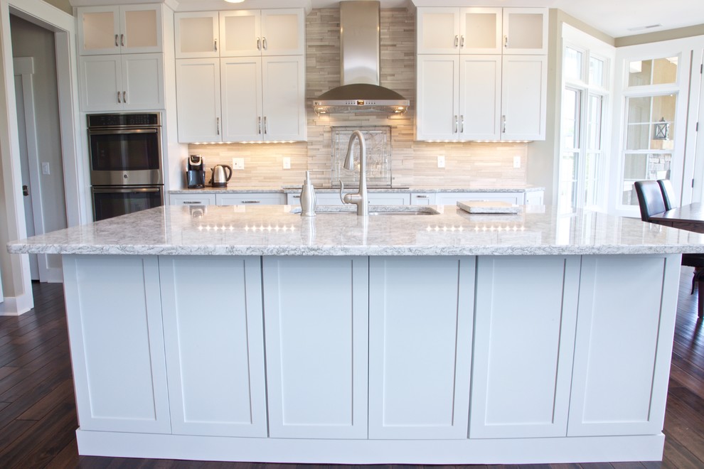 Inspiration for a mid-sized transitional galley eat-in kitchen remodel with white cabinets, granite countertops, beige backsplash, stone tile backsplash and stainless steel appliances