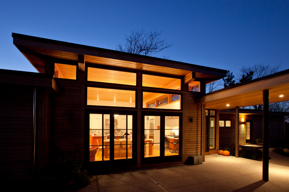Inspiration for a large contemporary one-storey brown house exterior in Boston with wood siding and a flat roof.