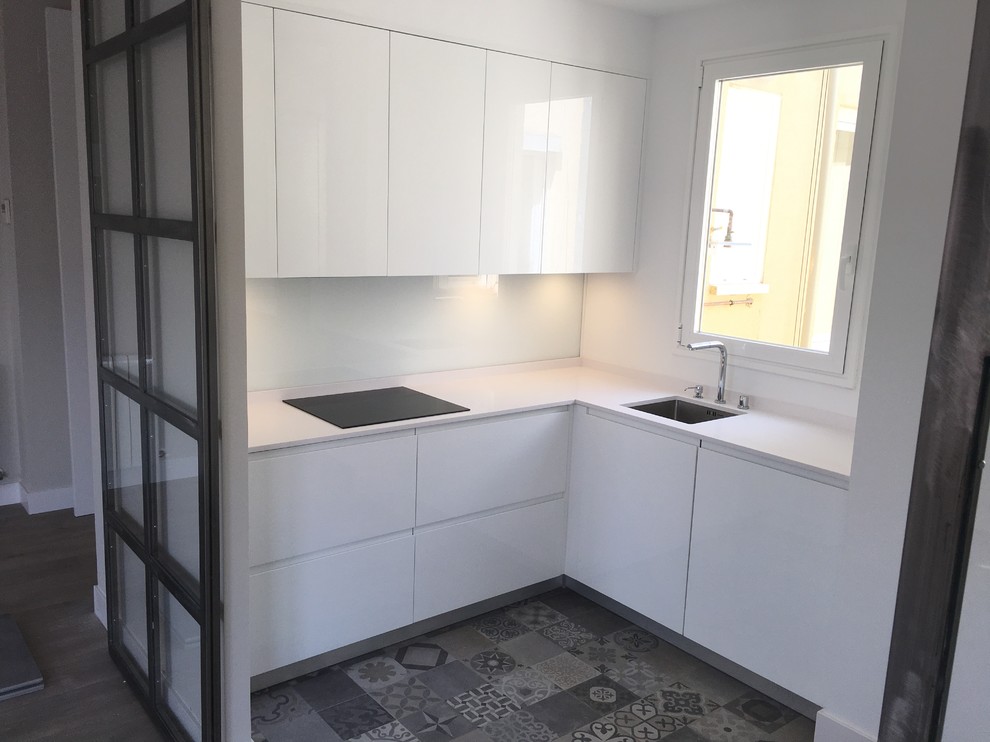 Photo of a mid-sized modern u-shaped eat-in kitchen in Madrid with an undermount sink, flat-panel cabinets, white cabinets, quartz benchtops, metallic splashback, window splashback, stainless steel appliances, ceramic floors, no island and grey floor.