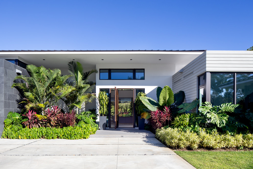 Große Moderne Haustür mit bunten Wänden, Porzellan-Bodenfliesen, Drehtür, hellbrauner Holzhaustür und grauem Boden in Miami
